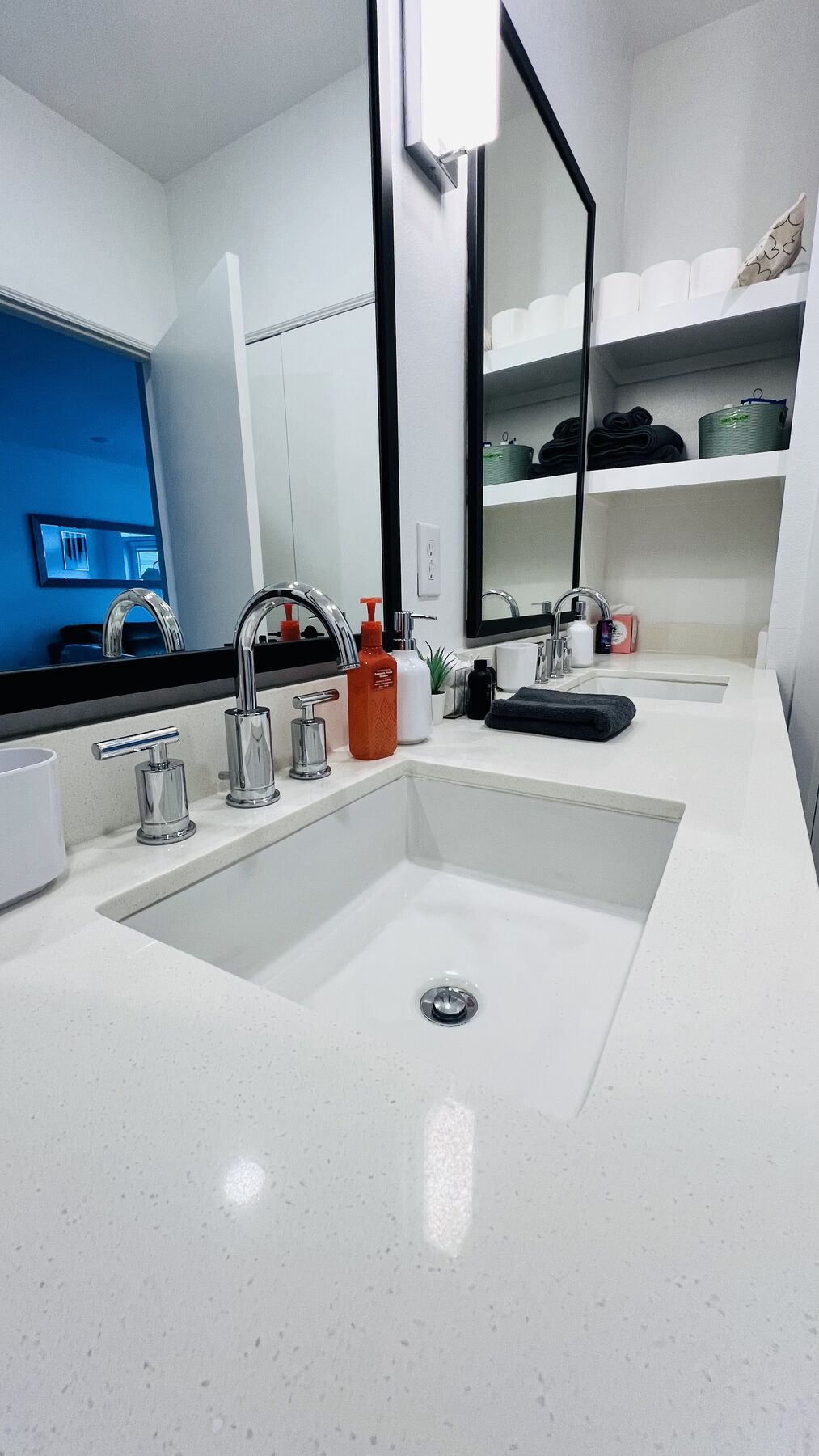 Bathroom with white quartz double vanity and black-framed mirrors